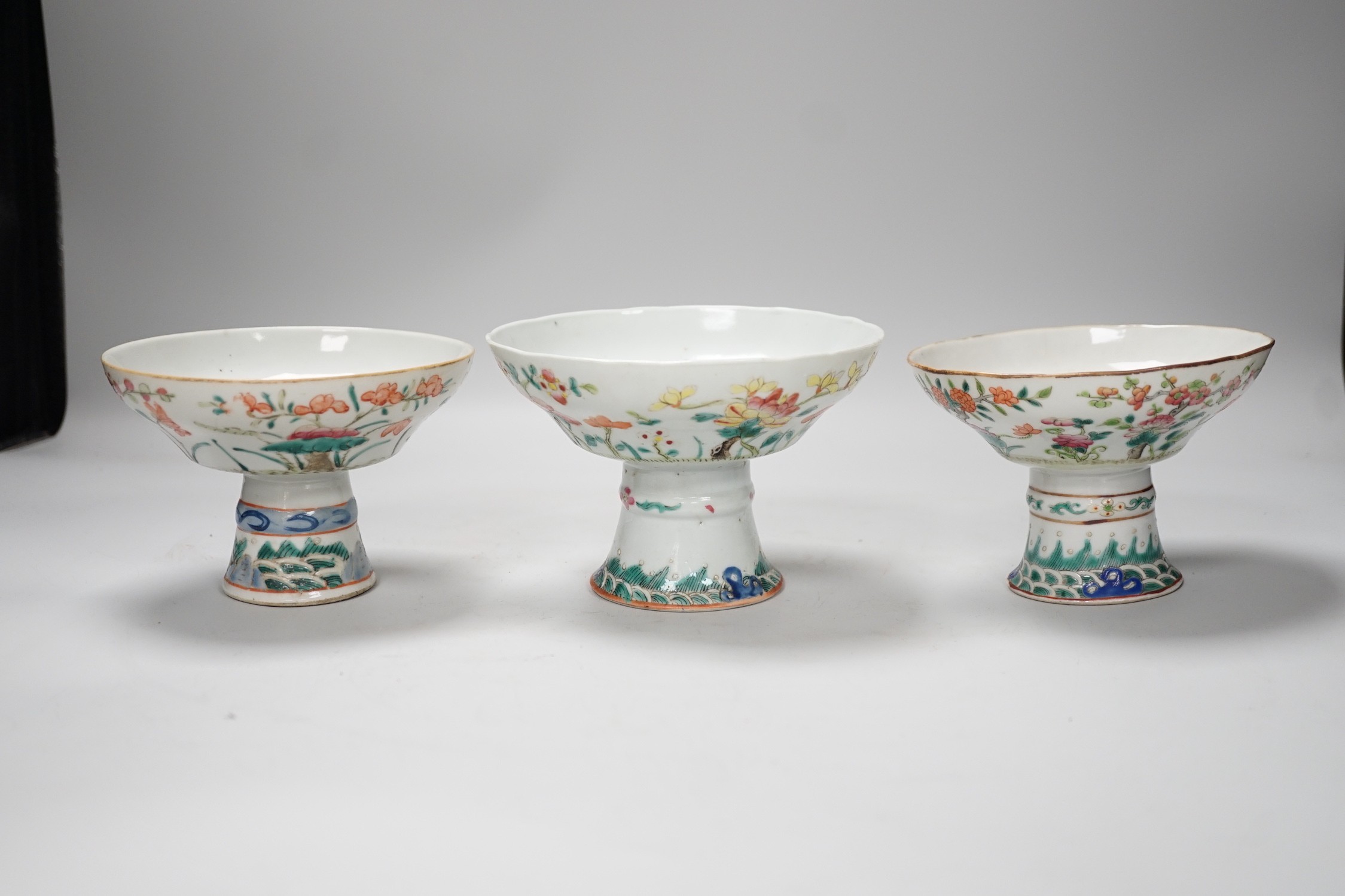 Three 19th century Chinese famille rose pedestal stem bowls, each painted with flowers and foliage, 9.5cm tall